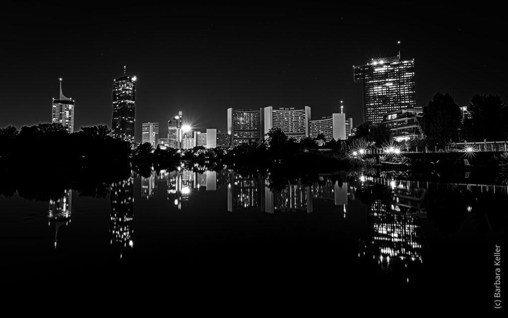 Nachtaufnahme in Wien: Kaiserwasser mit Spiegelung der nächtlichen Skyline von Wien mit Unocity