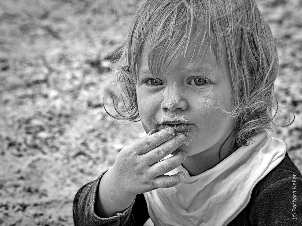 Portrait eines Kindes: Junge / Bub beim Sandspielen